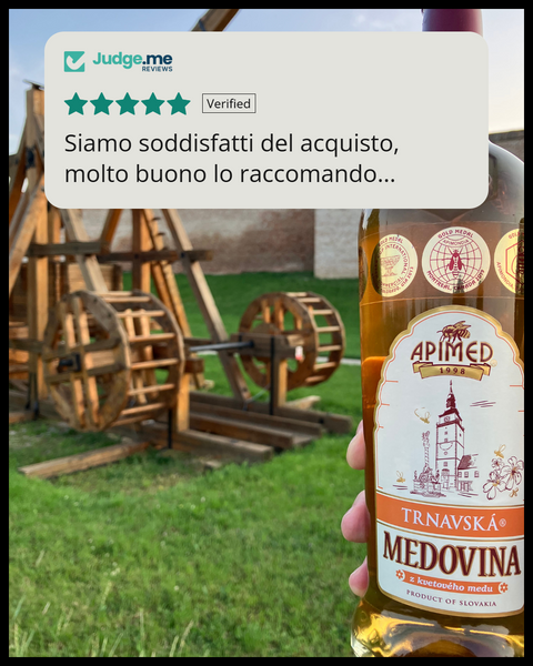 Bottiglia di Medovina Trnavska, idromele speziato, davanti a un trebuchet, con recensione di una cliente
